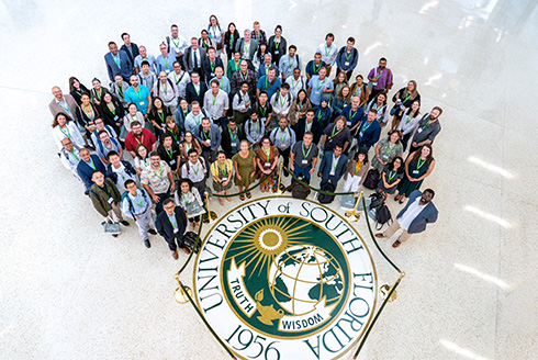Group shot of new faculty with USF seal