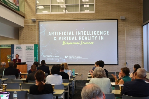 Julie Serovich at the podium giving opening remarks