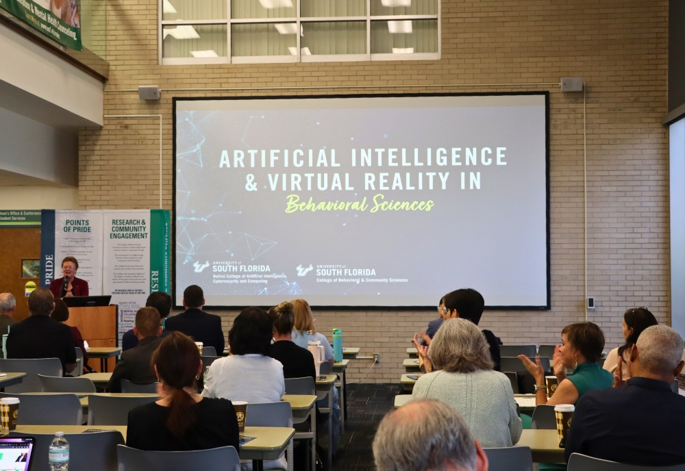 Julie Serovich at the podium giving opening remarks