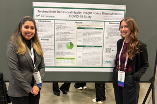 Jocelyn Jarvis and Sierra Tentis in front of their poster presentation