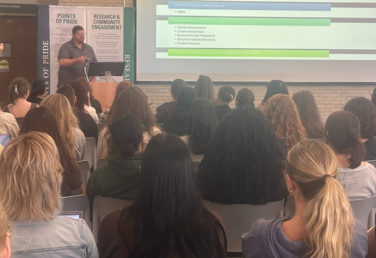 Travis Atchison presenting in the MHC Atrium to master's of social work students