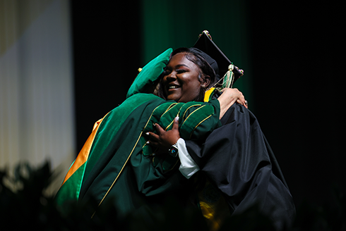 A graduate hugging a faculty member