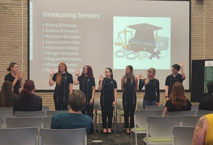 Students stand with their chords to celebrate the end-of-semester of their program