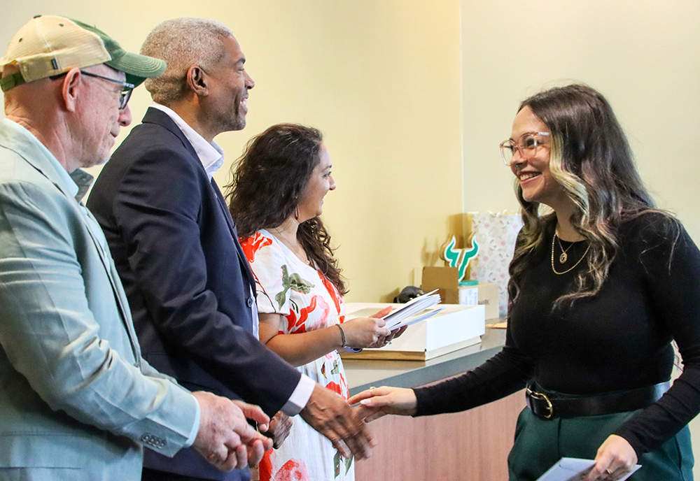 Students shake hands with professors