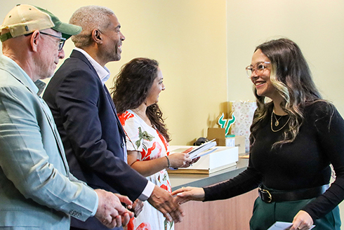 Students shake hands with professors