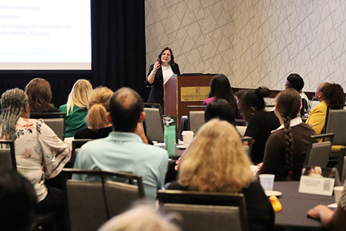 A presenter speaks to a full room