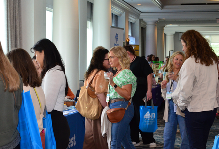 During breaks between presentations and workshops, attendees visit exhibitor tables to purchase books, items, or ask questions about services or resources offered.