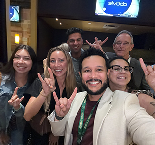 Anthony Concepcion and Raymond Miltenberger with other attendees take a selfie with horns up sign