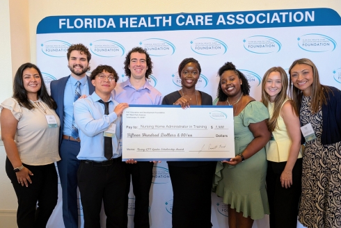 Left to right: Tiffany Sanchez, James Cleary, Thang Troung, Joseph Sacco, Delicia Kabamba, Lyse Garilus, Sophie Crant and Kacie Paul holding a big check
