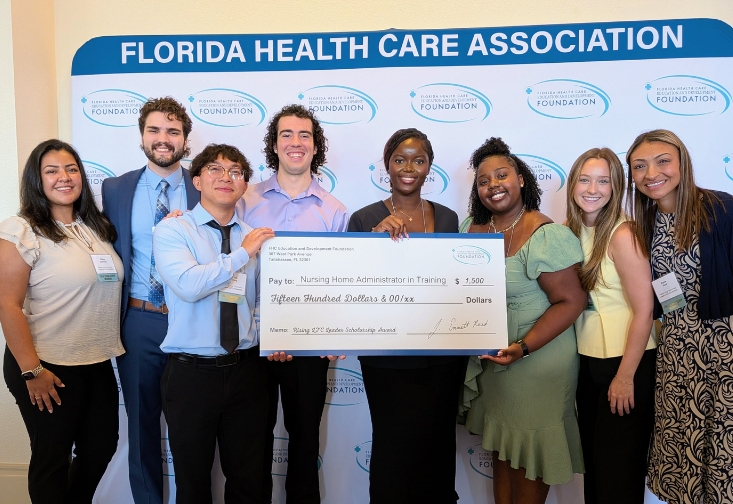 Left to right: Tiffany Sanchez, James Cleary, Thang Troung, Joseph Sacco, Delicia Kabamba, Lyse Garilus, Sophie Crant and Kacie Paul holding a big check