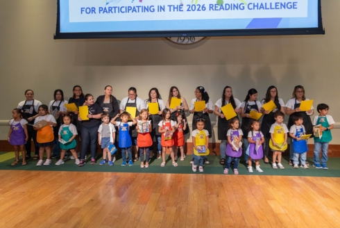 Children along with their HIPPY Home Visitors sing a song on stage