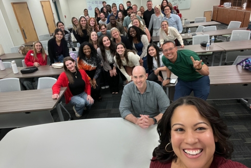 People smiling for a group photo at a conference
