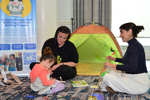 Adults play on the floor with a child during the NCPMI conference