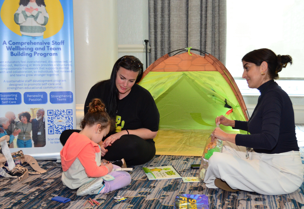Adults play on the floor with a child during the NCPMI conference