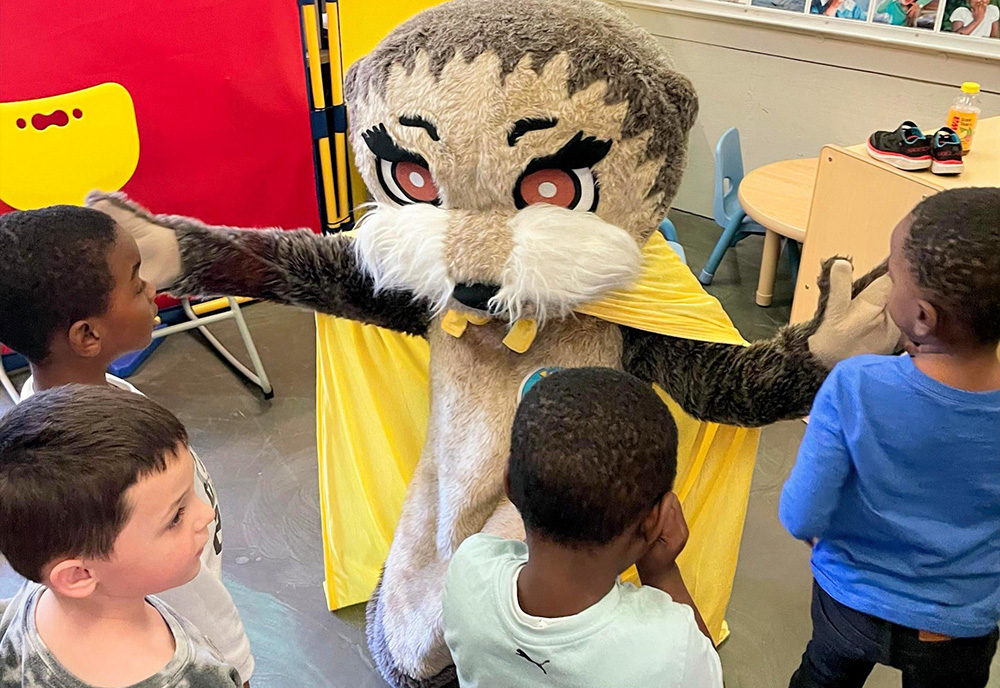 Josh the Otter hugs students