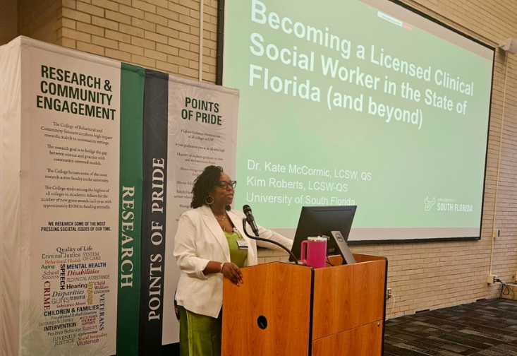 Kim Roberts standing at a podium