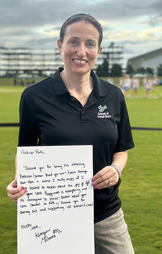 Jennifer Roth stands on the feild with her award