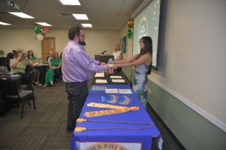 Jacob Blankenhorn receives his Alpha Phi Sigma membership certificate from Elaina Hawkins, chapter president.