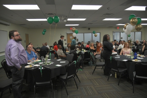 A room filled with attendees at the Alpha Phi Sigma Induction Ceremony