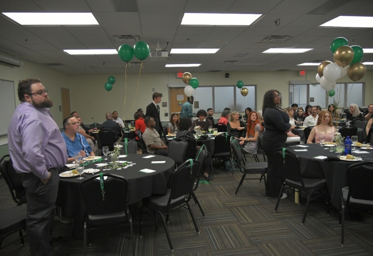 A room filled with attendees at the Alpha Phi Sigma Induction Ceremony