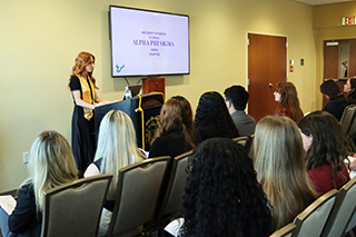 Colby Valentine stands at the front of the room