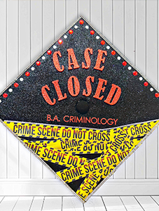 Grad cap with "Case Closed - BA Criminology" and caution tape