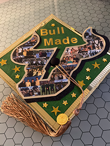 Grad cap decorated with photos with text reading "Bull Made"