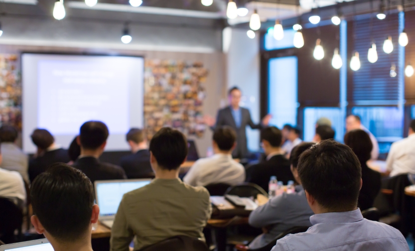 A corporate training session with an instructor standing at the head of class