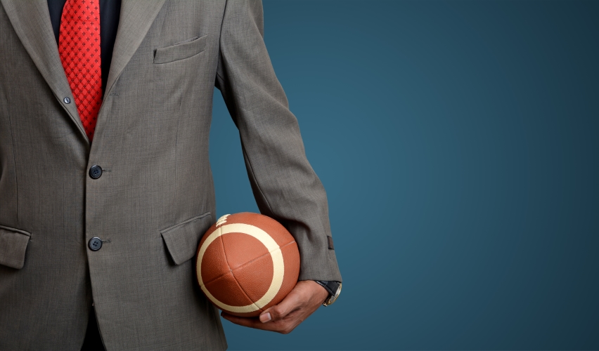 A man in a suit holding a football