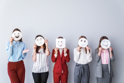 A group holding up paper plates with emotive faces drawn on