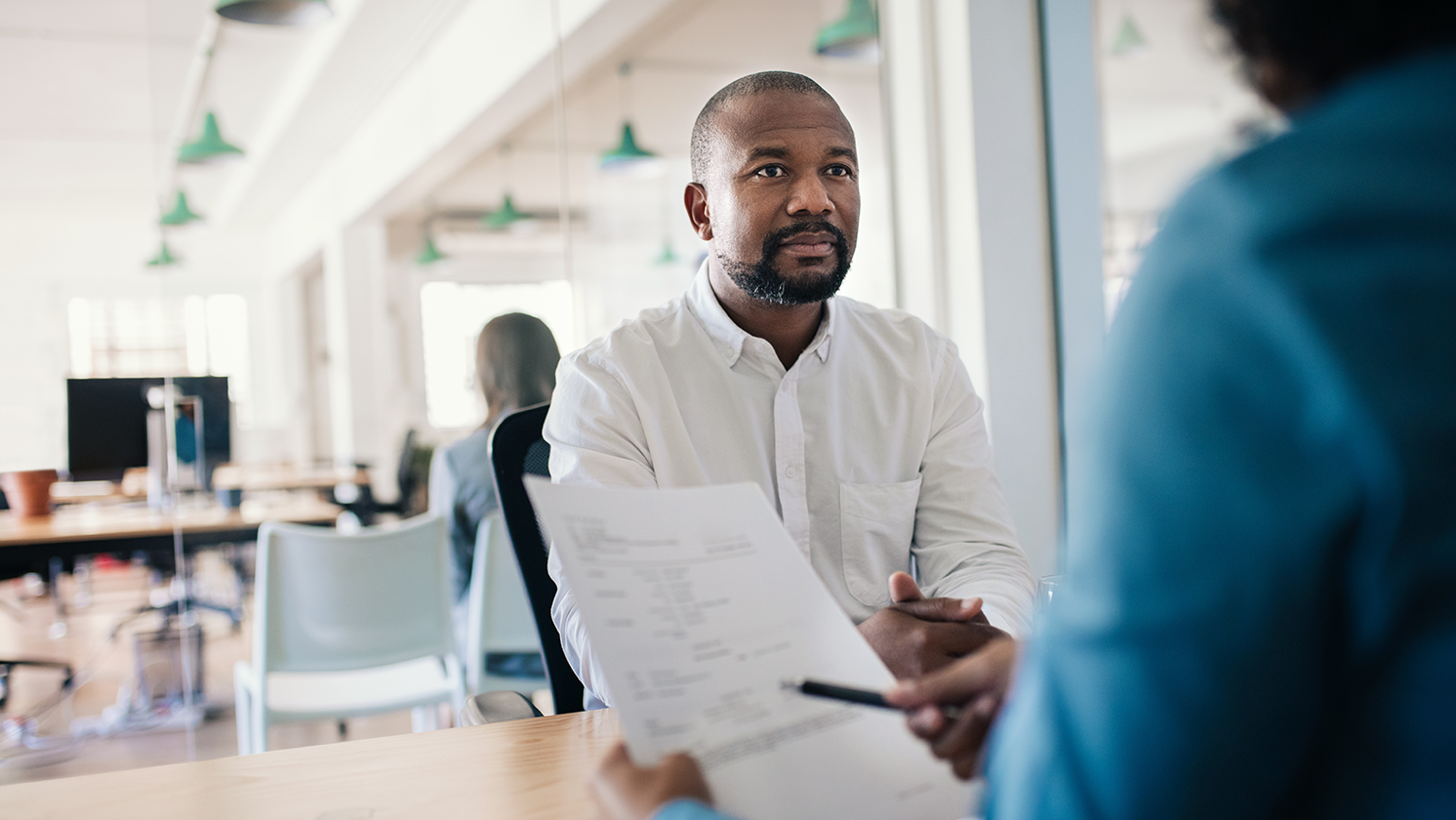 man sits listening to someone talking