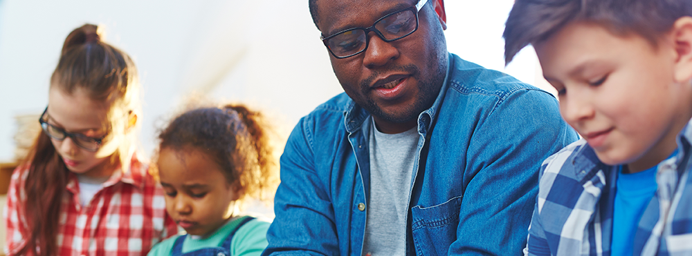 an adult and children read a book