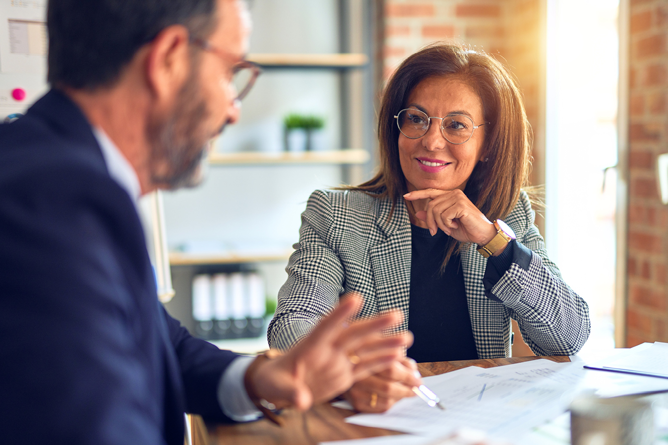 A woman and man wearing business attire and glasses