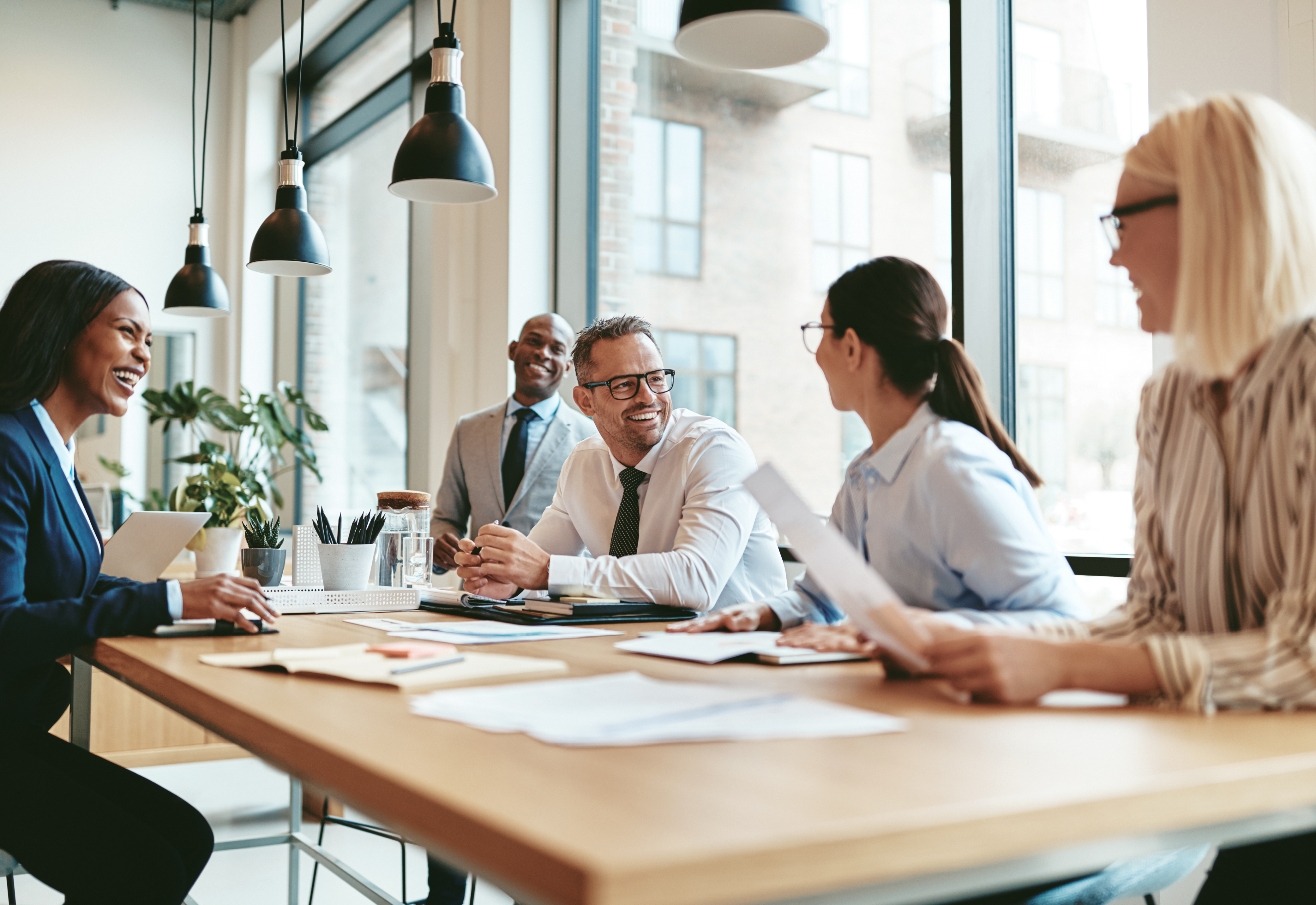 A group of people wearing business attire sitting at a table together 