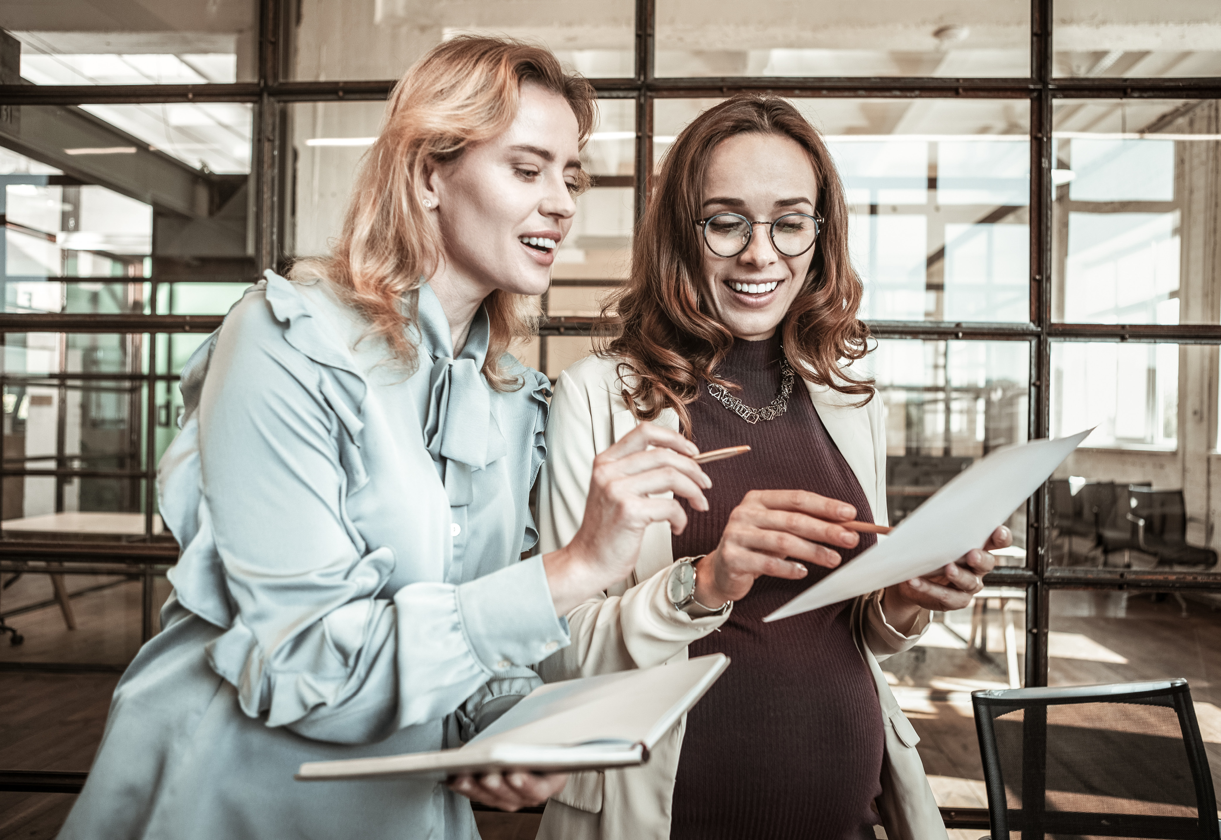 Two women in an office looking over a sheet of paper