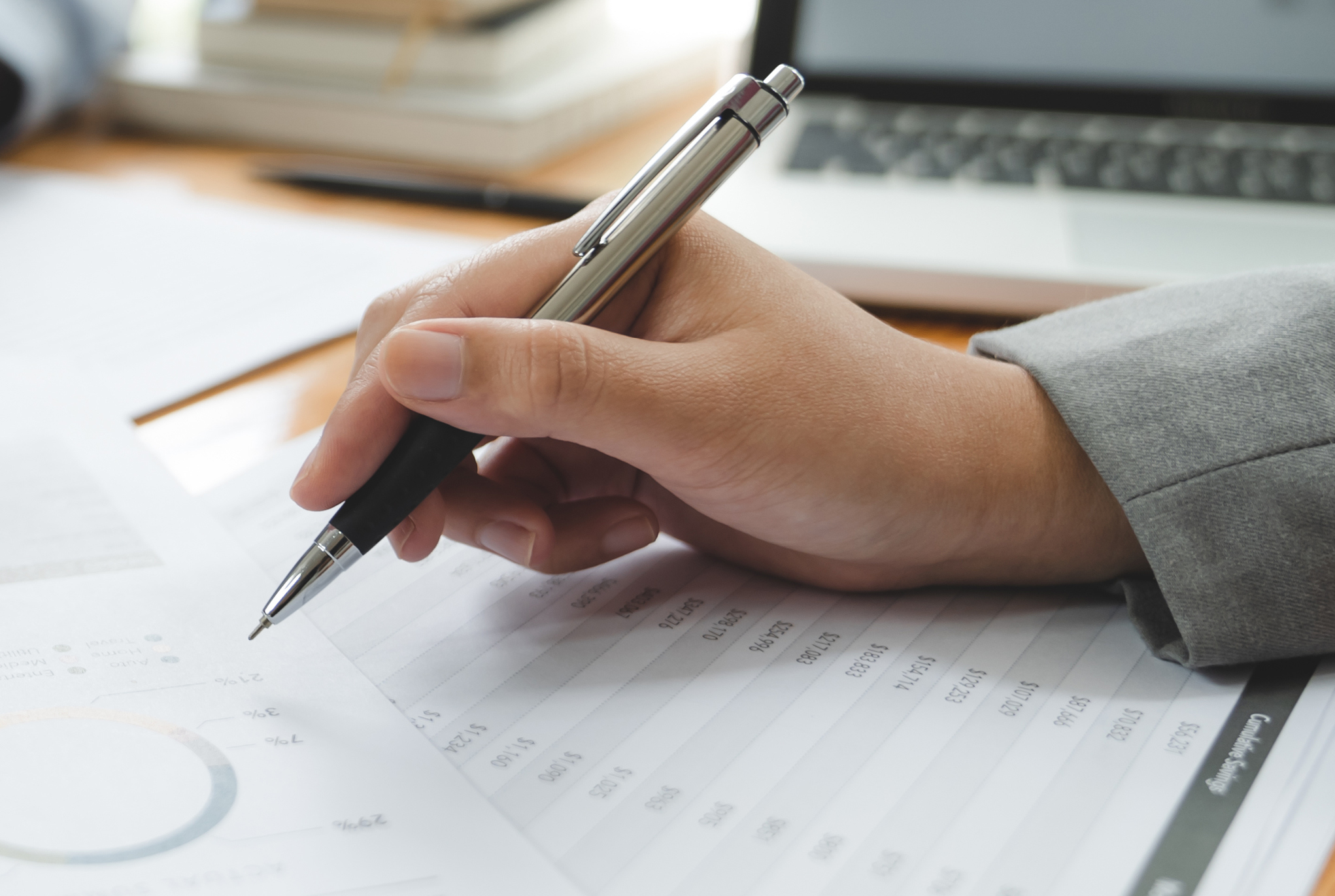 A hand holding a pen on top of paperwork
