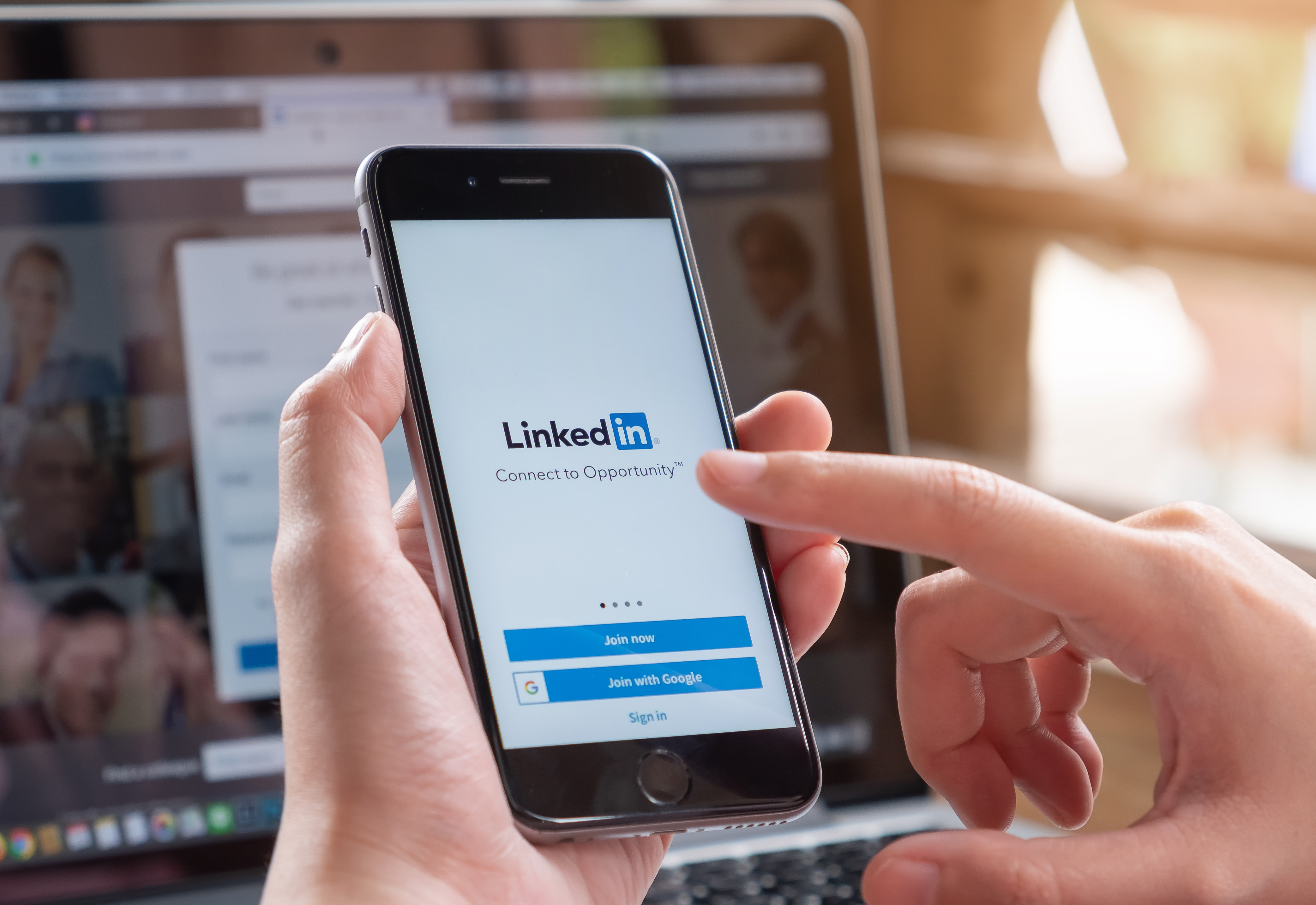 A person holding their phone logging in to LinkedIn