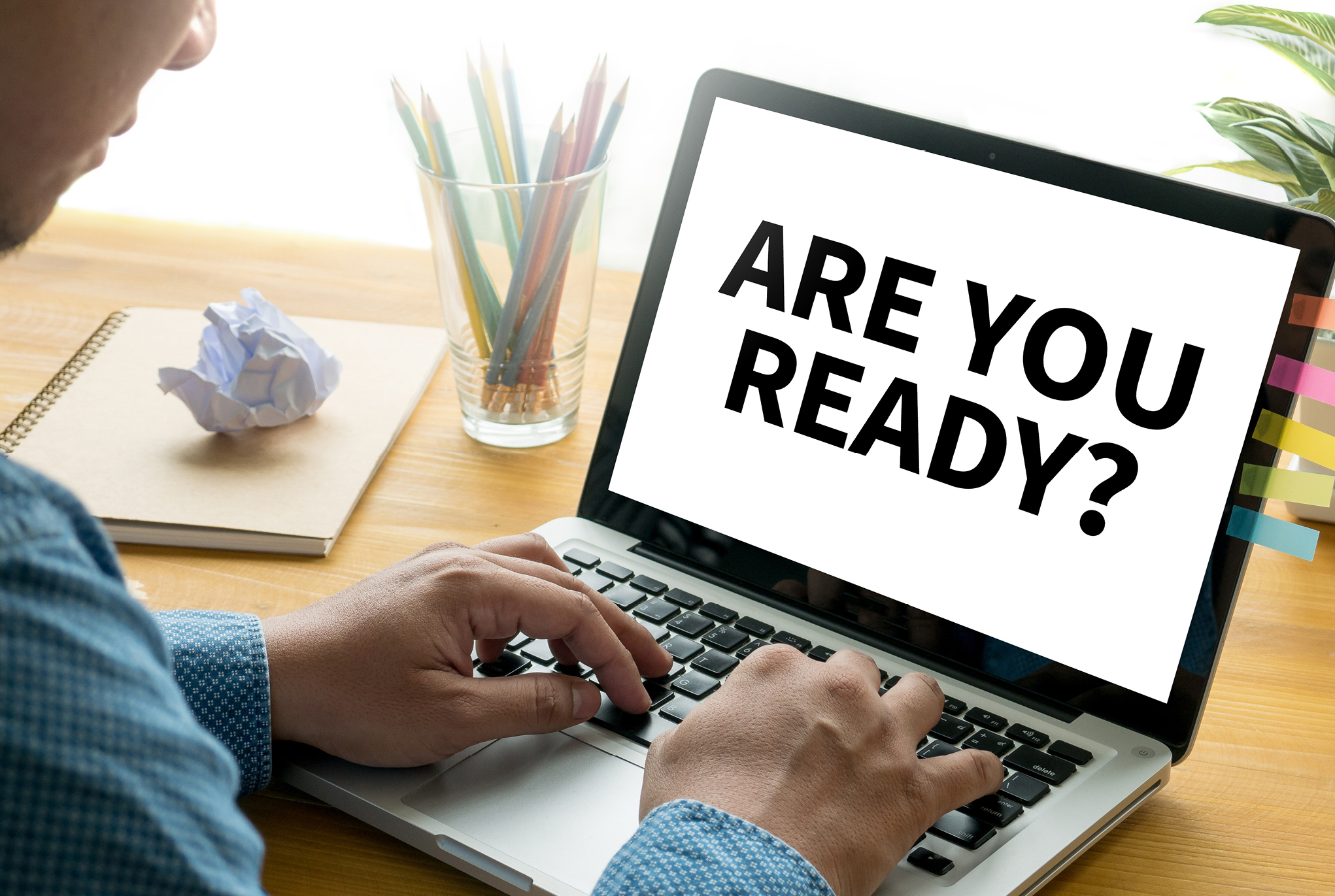 A person sitting in front of a laptop that says,