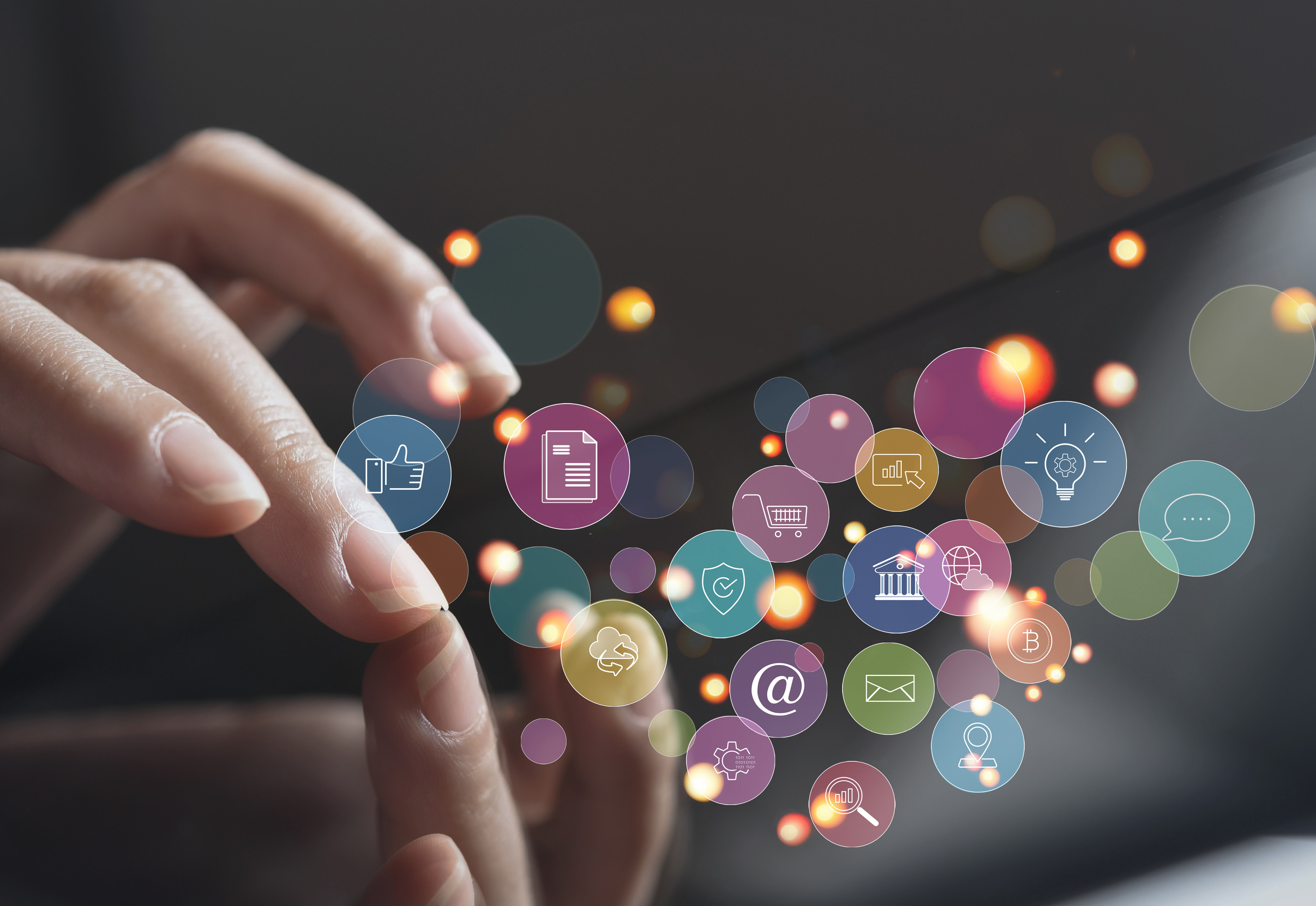 A hand touching a screen with social media related icons 
