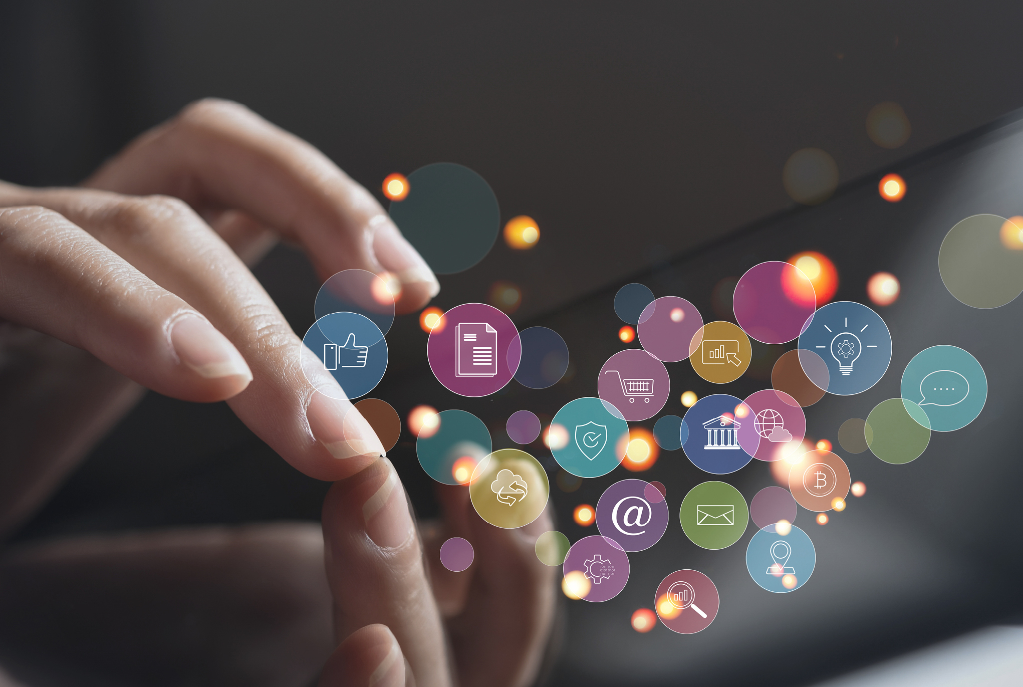 A hand touching a screen with social media related icons