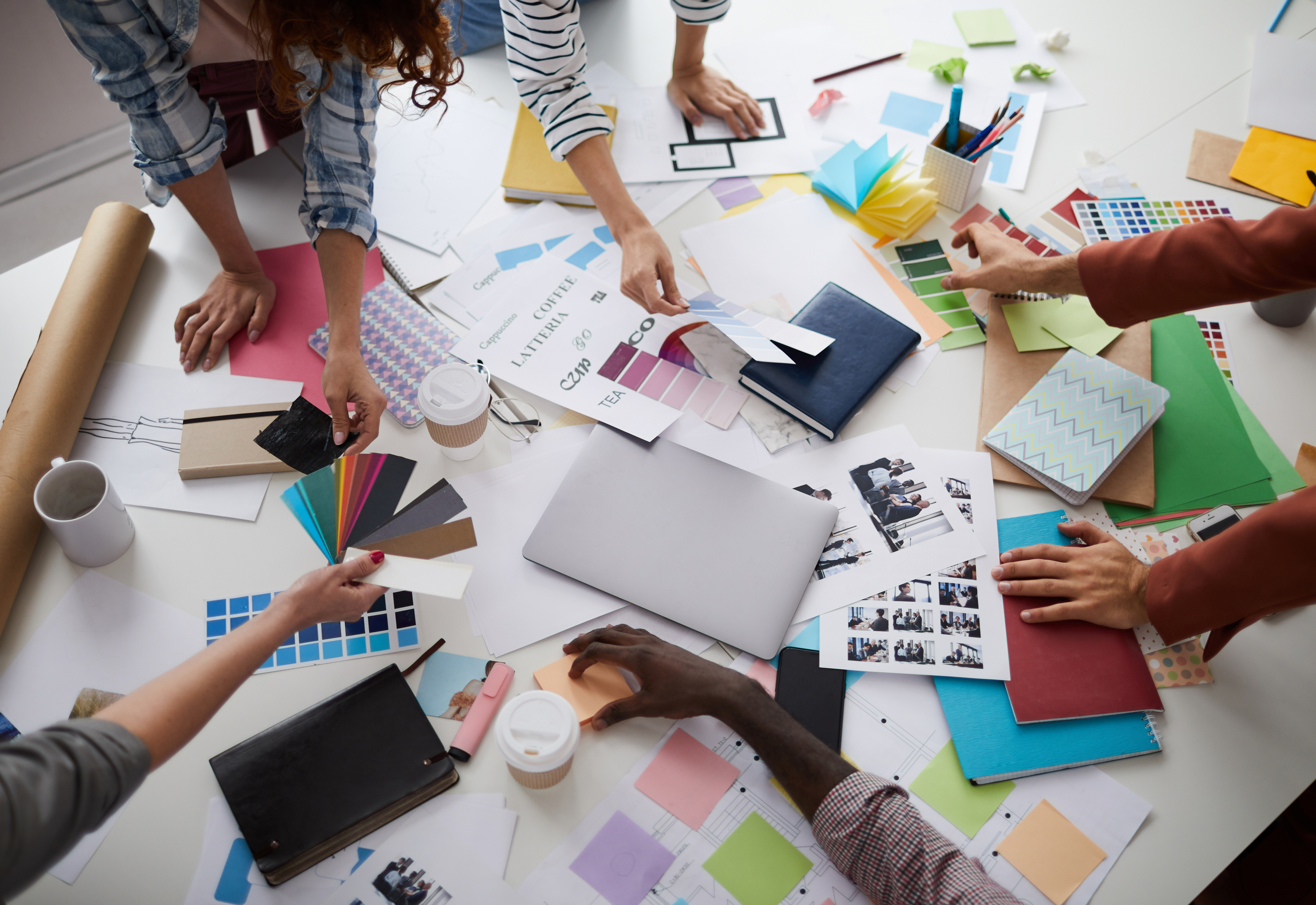 A group of people working on a project with materials scattered around a table