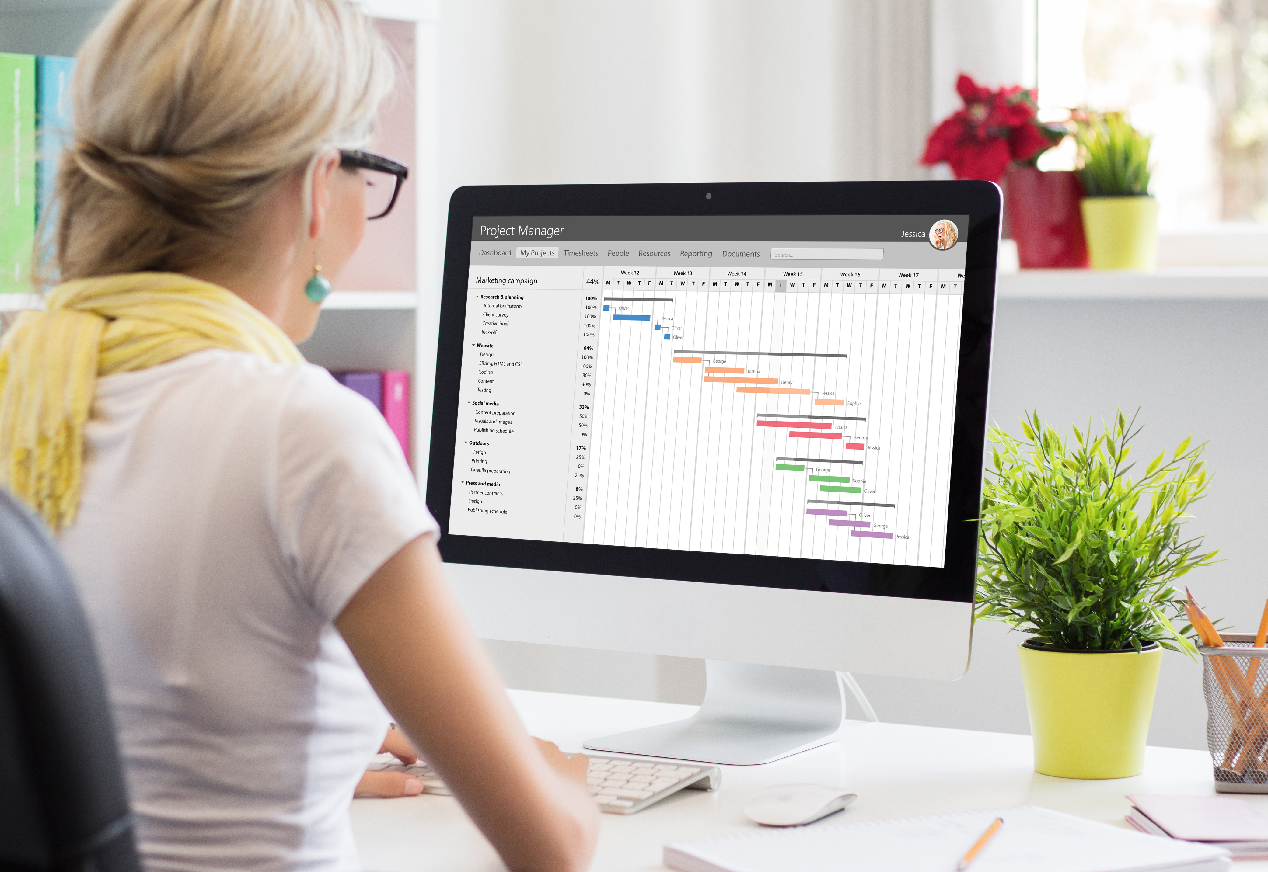 A woman sitting at her desk working on a graph on her computer