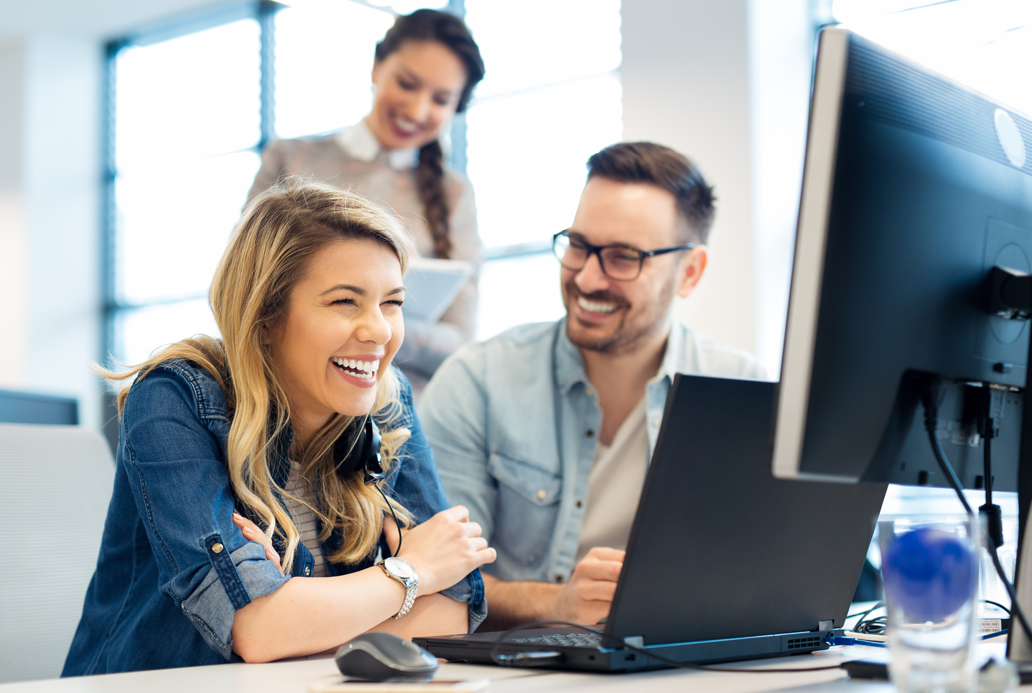 A group of people sitting at a desk with a computer