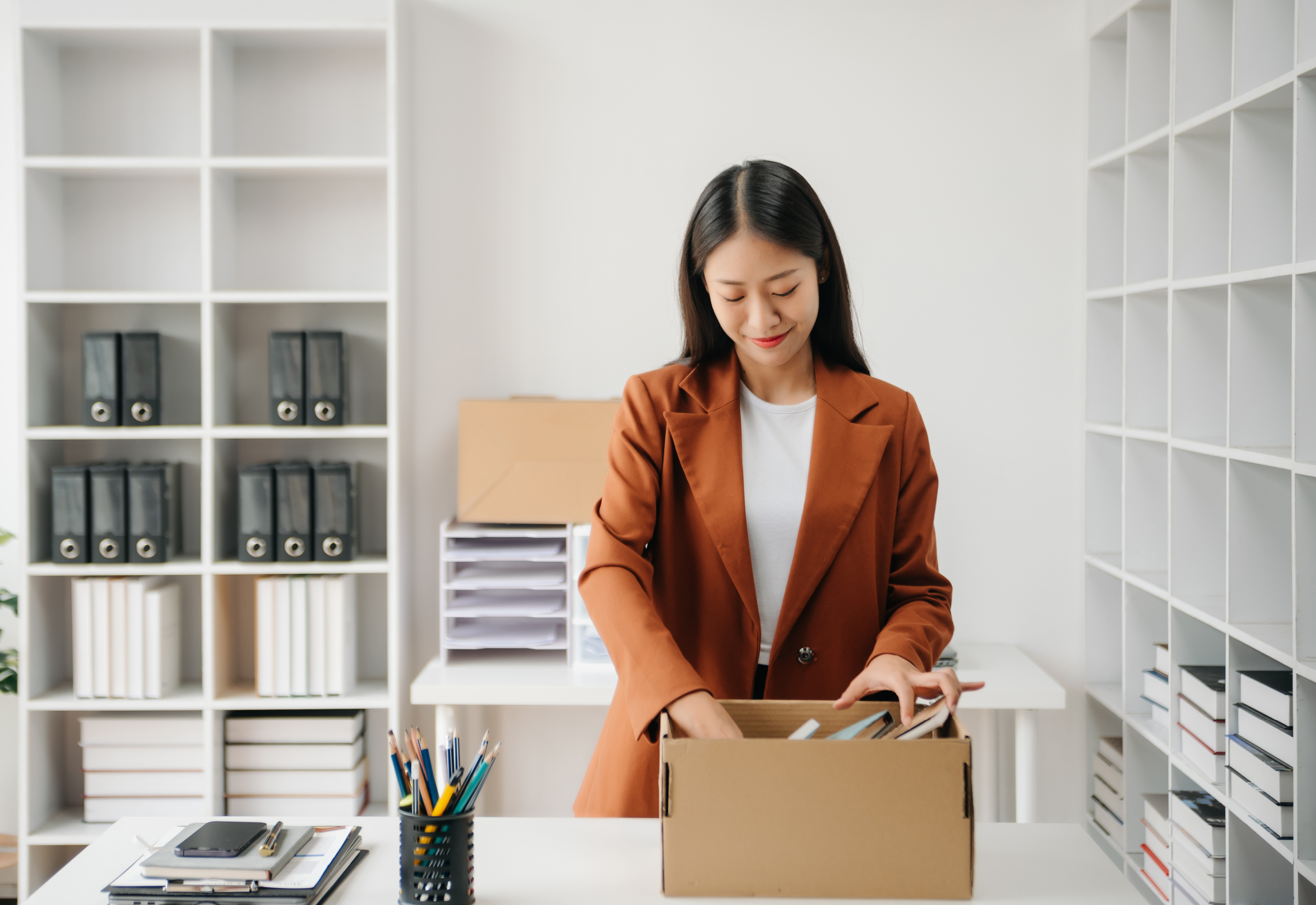 A woman packing up the items on her desk into a box