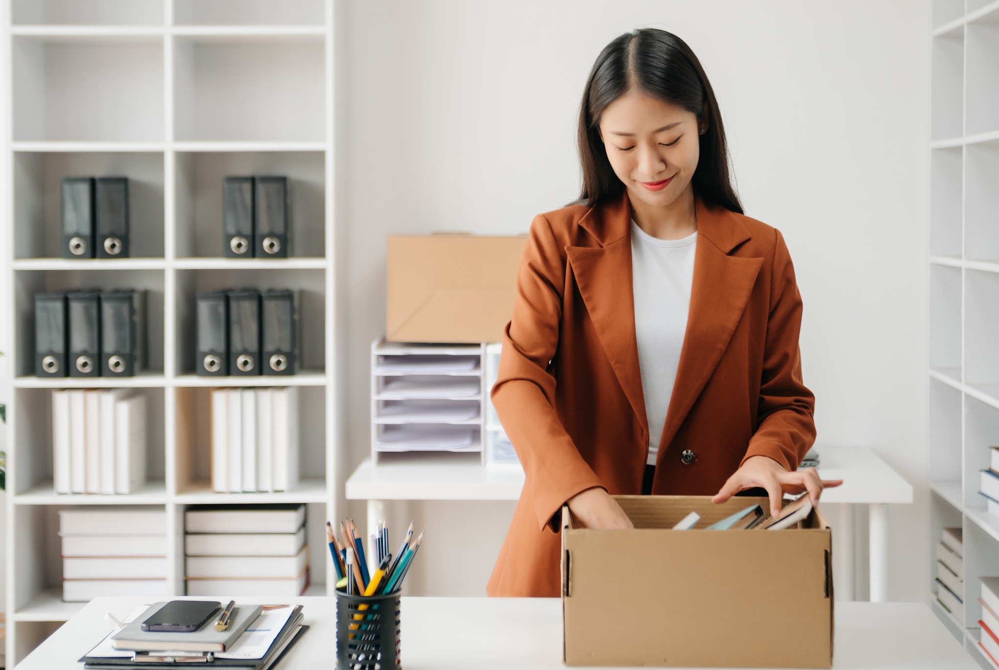 A woman packing up the items on her desk into a box