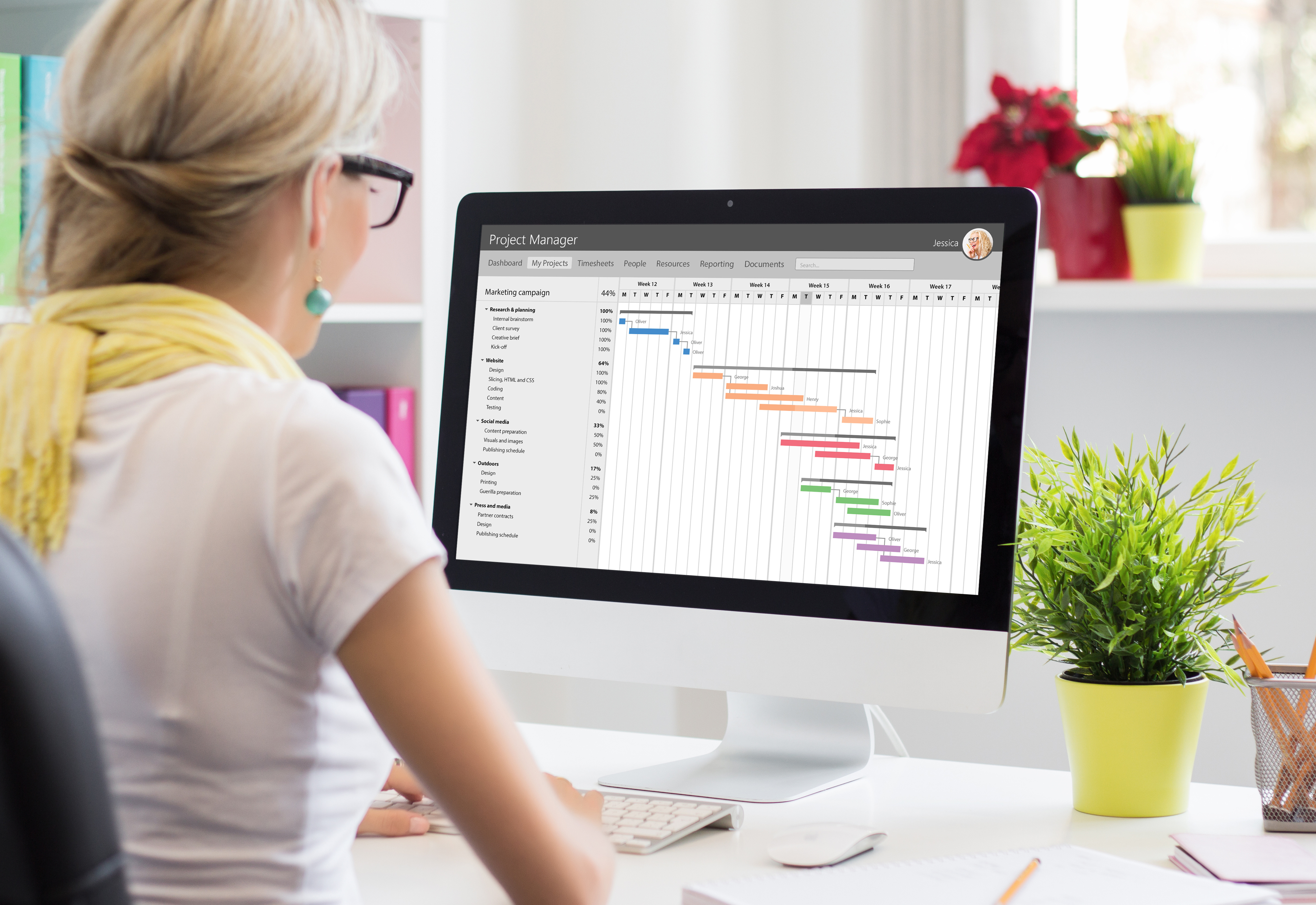 A woman sitting in front of her computer looking at a graph on her screen