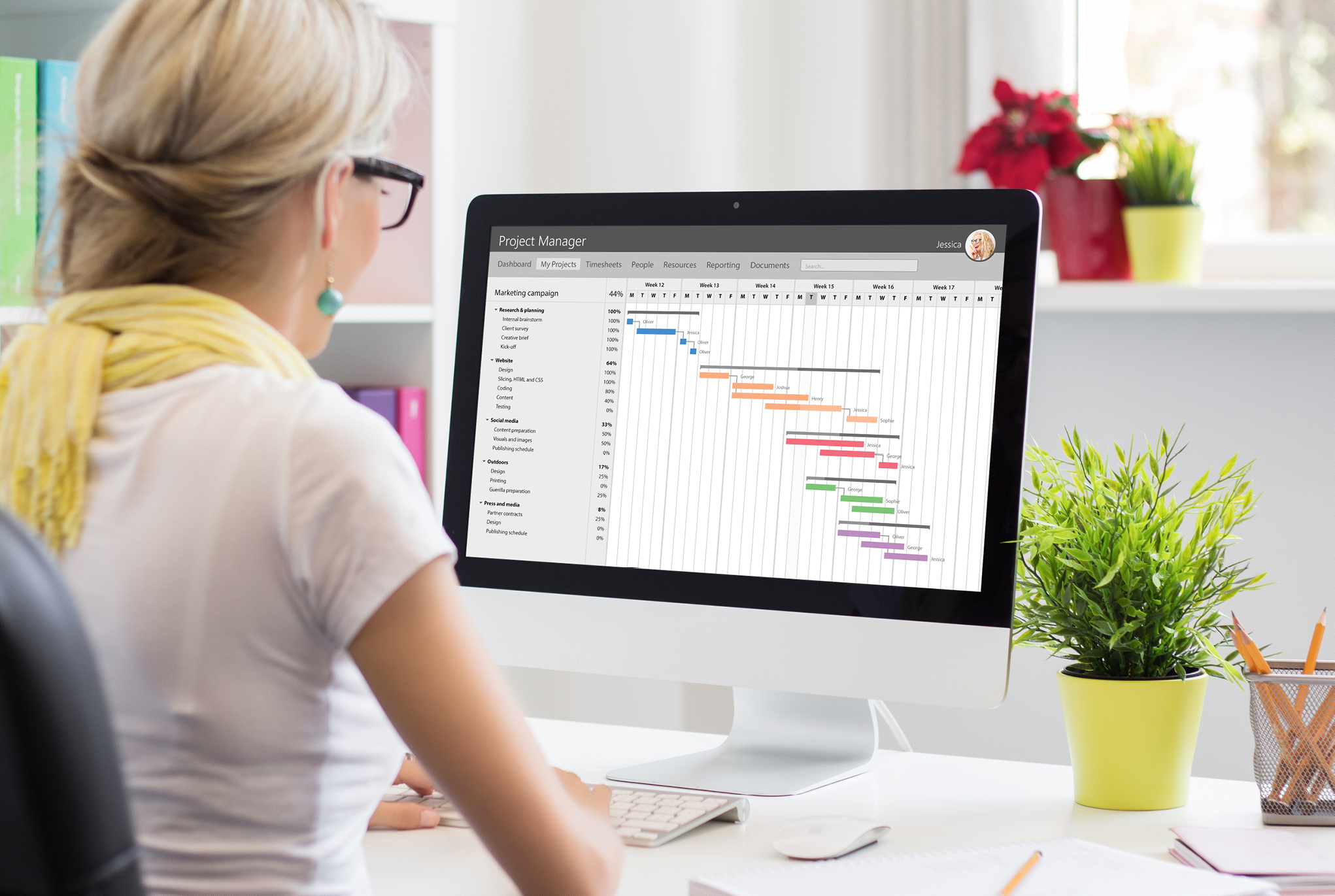 A woman sitting in front of her computer looking at a graph on her screen