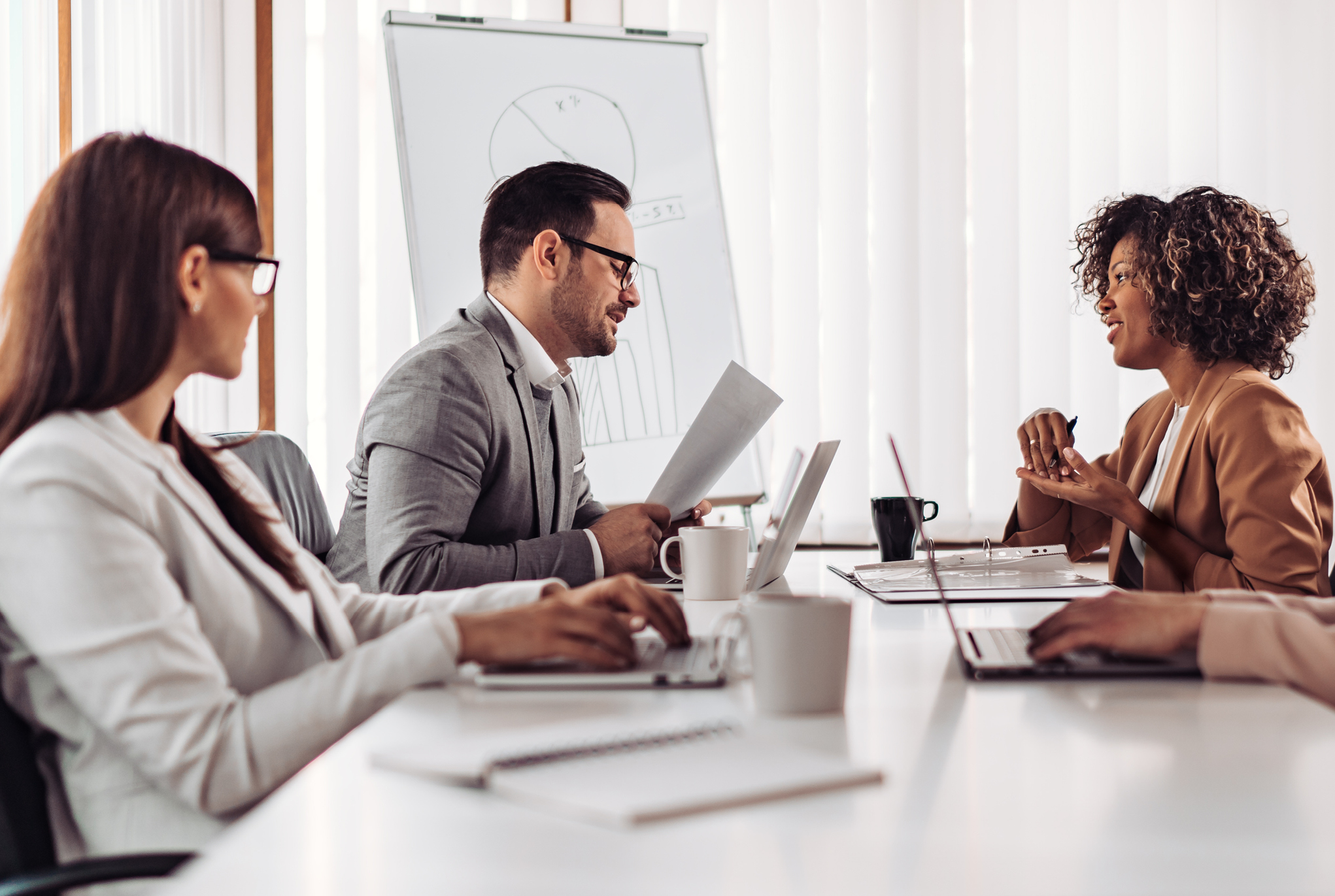 A group of people sitting at a table having a meeting