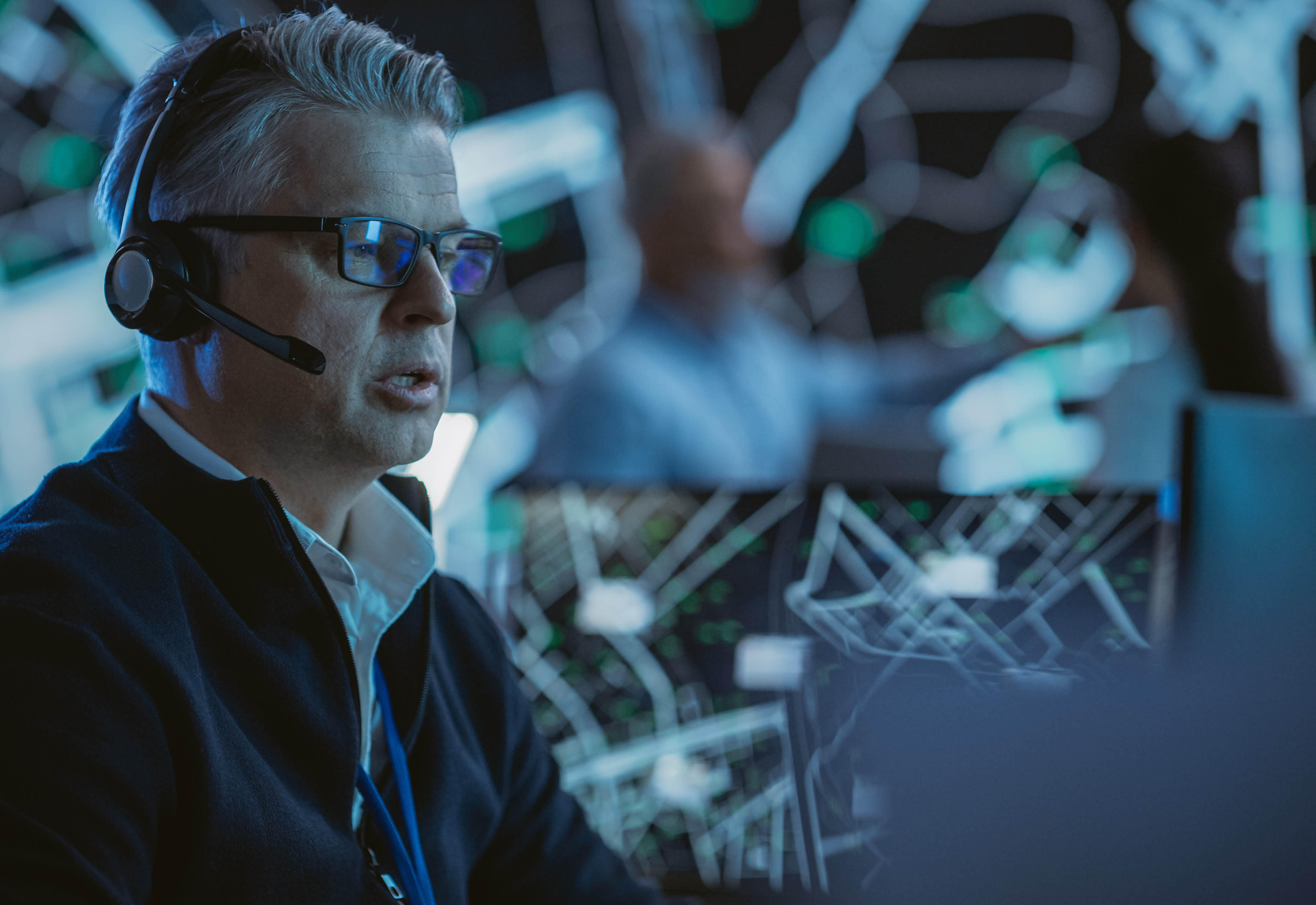 A man wearing eyeglasses and a headset