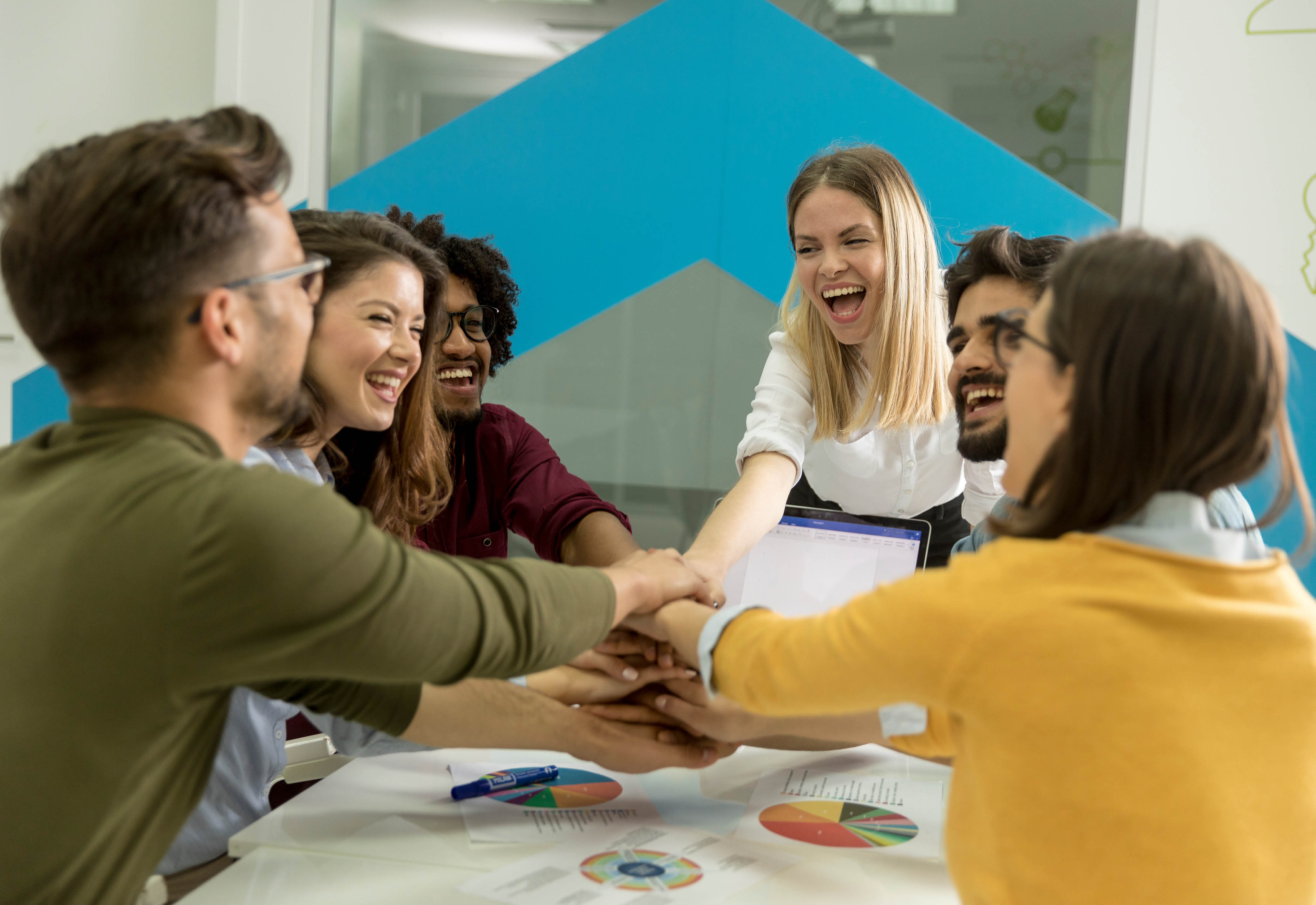 A group of people stacking their hands together